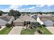 Home with a paver driveway, neutral color scheme, and mature landscaping; outlined in blue at 2096 Callaway Dr, The Villages, FL 32162