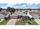 Home with a paver driveway, neutral color scheme, and mature landscaping; outlined in blue at 2096 Callaway Dr, The Villages, FL 32162