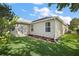 Home's backyard shows a well-maintained lawn and neutral-colored siding with white trim around the door and windows at 2096 Callaway Dr, The Villages, FL 32162