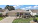 Charming single-story home featuring well-manicured landscaping and a brick-paved driveway at 2096 Callaway Dr, The Villages, FL 32162