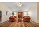 Bright living room with armchairs, hardwood floors, and natural light from the windows at 2096 Callaway Dr, The Villages, FL 32162