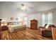 Inviting main bedroom featuring wood floors, natural light, and a comfortable seating area at 2096 Callaway Dr, The Villages, FL 32162