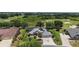 Aerial view displays a home with solar panels, golf course and lake view, and elaborate landscaping at 2125 Horizon Run, The Villages, FL 32162