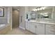 Bathroom with double vanities featuring stone countertops and tile shower at 2125 Horizon Run, The Villages, FL 32162