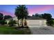 Charming single-story home with a three-car garage, palm tree, and well-maintained landscaping at 2125 Horizon Run, The Villages, FL 32162
