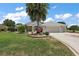 Beautiful single-story home featuring a three-car garage, well-manicured lawn, and mature palm trees at 2125 Horizon Run, The Villages, FL 32162