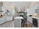 Open kitchen with white cabinets, a center island, stainless steel appliances, and views into the living room at 2125 Horizon Run, The Villages, FL 32162