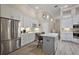 Stylish kitchen with white cabinets, a large island, stainless steel appliances, and modern lighting at 2125 Horizon Run, The Villages, FL 32162