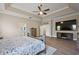 Spacious main bedroom with tray ceiling, wood floors, and a view into the ensuite bathroom at 2125 Horizon Run, The Villages, FL 32162