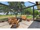 Relaxing outdoor seating area with a fire pit, wooden chairs, and a screened enclosure at 2125 Horizon Run, The Villages, FL 32162