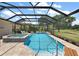 Inviting pool with screened-in enclosure, spa, and lush landscaping perfect for relaxation and entertainment at 2125 Horizon Run, The Villages, FL 32162