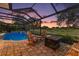 Inviting screened-in pool and patio with a charming outdoor fireplace and furniture at 2125 Horizon Run, The Villages, FL 32162