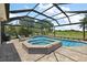 Relaxing screened pool with a spa overlooking a lush green landscape at 2125 Horizon Run, The Villages, FL 32162