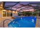 Screened pool area with hot tub, waterfall feature, and brick pavers, perfect for relaxation and outdoor enjoyment at 2125 Horizon Run, The Villages, FL 32162