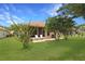 Landscaped backyard featuring a screened lanai with patio and lush lawn at 21646 Stirling Pass, Leesburg, FL 34748