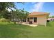 Well-maintained backyard with brick paver patio, grill, lush lawn, and mature landscaping at 21646 Stirling Pass, Leesburg, FL 34748