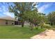 Lush backyard showcasing a screened lanai, mature trees and manicured lawn at 21646 Stirling Pass, Leesburg, FL 34748