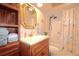 Bathroom features a shower, vanity with sink, gold mirror, storage cabinets, and nautical themed shower curtain at 21646 Stirling Pass, Leesburg, FL 34748
