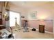 Bright bedroom with ceiling fan, pink walls, a faux giraffe, exercise equipment, and wood laminate flooring at 21646 Stirling Pass, Leesburg, FL 34748