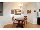 Cozy dining area featuring a round table with wooden chairs, decorative chandelier, and natural light at 21646 Stirling Pass, Leesburg, FL 34748