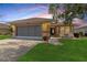 Charming single-story home featuring a screened garage, welcoming front porch with rocking chairs, and a well-manicured lawn at 21646 Stirling Pass, Leesburg, FL 34748