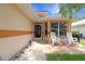 Inviting front porch with rocking chairs, a small table, and decorative accents creating a cozy outdoor space at 21646 Stirling Pass, Leesburg, FL 34748