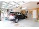 Well-organized garage showcasing a parked gray SUV, tool racks, and ample storage space at 21646 Stirling Pass, Leesburg, FL 34748