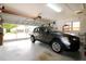 Bright, spacious garage featuring an overhead door with windows and a parked gray SUV at 21646 Stirling Pass, Leesburg, FL 34748