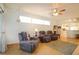 Comfortable living room with hardwood floors, recliner seating, ceiling fan, and plenty of natural light at 21646 Stirling Pass, Leesburg, FL 34748
