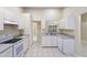 Clean and spacious kitchen features white cabinets, ample counter space, and tile flooring at 2304 Clementine Trl, Clermont, FL 34714