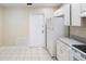 Bright and airy kitchen offers ample cabinet space, tile flooring, and access to the backyard at 2304 Clementine Trl, Clermont, FL 34714
