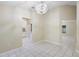 An open-plan living room with tile flooring, neutral walls, and a decorative chandelier at 2304 Clementine Trl, Clermont, FL 34714