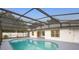 Sparkling screened-in pool surrounded by a large patio area, perfect for outdoor enjoyment and relaxation at 2304 Clementine Trl, Clermont, FL 34714