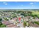 Aerial view of a residential area featuring houses, landscaping, and a community pool and golf course at 2325 Kenya St, The Villages, FL 32162