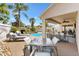 Lush backyard oasis with a pool, waterfall feature, and comfortable patio seating, perfect for entertaining and relaxation at 2325 Kenya St, The Villages, FL 32162