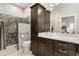 Modern bathroom featuring a walk-in shower with elegant tile work and dark wood cabinetry at 2325 Kenya St, The Villages, FL 32162