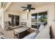 Cozy covered lanai with comfortable seating and ceiling fan, offering a relaxing space to enjoy the outdoors at 2325 Kenya St, The Villages, FL 32162