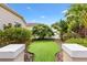 Landscaped walkway leads to a tranquil garden featuring lush greenery and a manicured lawn at 2325 Kenya St, The Villages, FL 32162