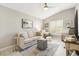 Cozy living room with neutral colors, plenty of seating, and lots of light from the window at 2325 Kenya St, The Villages, FL 32162
