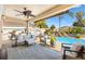 Beautiful outdoor patio with a pool, lush landscaping, and comfortable seating, creating a perfect backyard retreat at 2325 Kenya St, The Villages, FL 32162