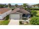 Aerial view of a charming home featuring a garage, screened lanai, and manicured landscaping at 2348 Riley Rd, The Villages, FL 32162