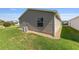 View of the vinyl siding, green grass, and minimal landscaping around the house at 2348 Riley Rd, The Villages, FL 32162