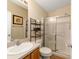 Bathroom featuring a vanity, mirror, shelving, and walk-in shower with sliding glass doors at 2348 Riley Rd, The Villages, FL 32162