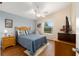 Bedroom with light blue walls, ceiling fan, wood floors and a window with a view of greenery at 2348 Riley Rd, The Villages, FL 32162