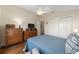 Bedroom with wood floors, ceiling fan, closet and dressers, offering ample storage space at 2348 Riley Rd, The Villages, FL 32162