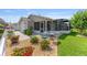 Outdoor view of a home with gravel landscaping, screened lanai and an attached garage at 2348 Riley Rd, The Villages, FL 32162