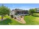A well-maintained property with a screened porch and a lush, green lawn at 2348 Riley Rd, The Villages, FL 32162