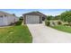 Charming one-story home featuring an attached garage and well-manicured lawn at 2348 Riley Rd, The Villages, FL 32162