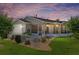 Backyard view of a cozy home with screened lanai, set in a landscaped yard at sunset at 2348 Riley Rd, The Villages, FL 32162