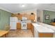 Well-lit kitchen with white appliances, tile flooring, and ample counter space at 2348 Riley Rd, The Villages, FL 32162